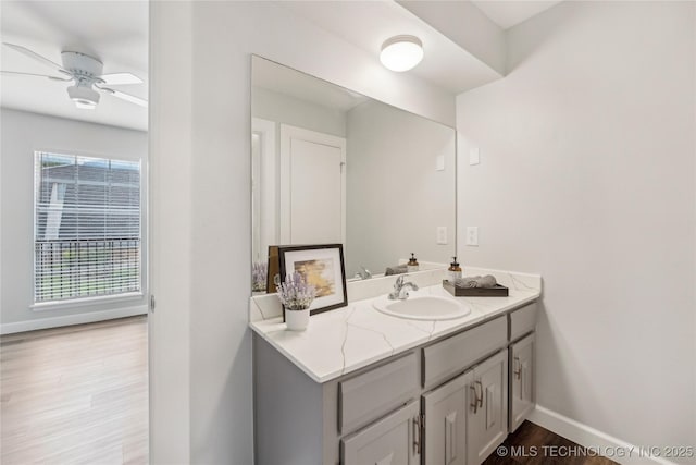 4440 68th St Unit 486, Tulsa, OK 74136 - bathroom with vanity, wood finished floors, a ceiling fan, and baseboards