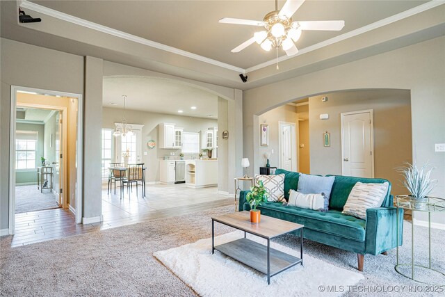 10473 E 143rd Ct N, Collinsville, OK 74021 - living area with arched walkways, light colored carpet, a ceiling fan, ornamental molding, and baseboards