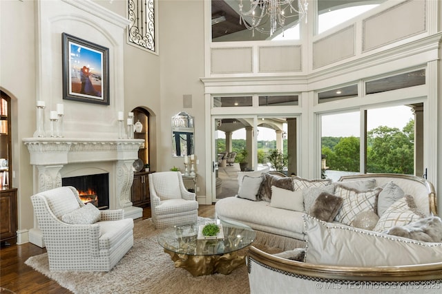 5879 N Eagle Summit Rd, Owasso, OK 74055 - living area featuring a towering ceiling, a high end fireplace, a chandelier, and wood finished floors