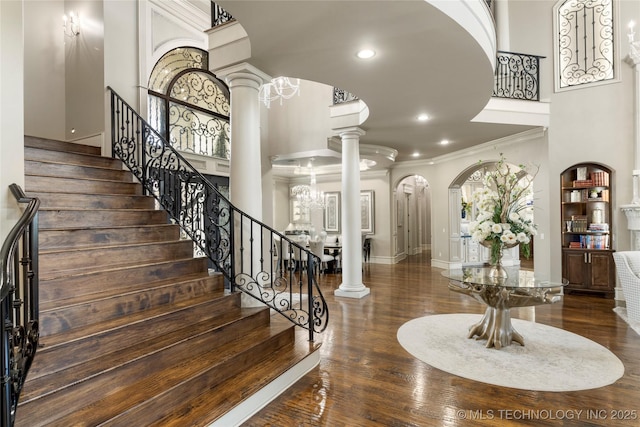 5879 N Eagle Summit Rd, Owasso, OK 74055 - stairs with crown molding, ornate columns, arched walkways, a towering ceiling, and recessed lighting