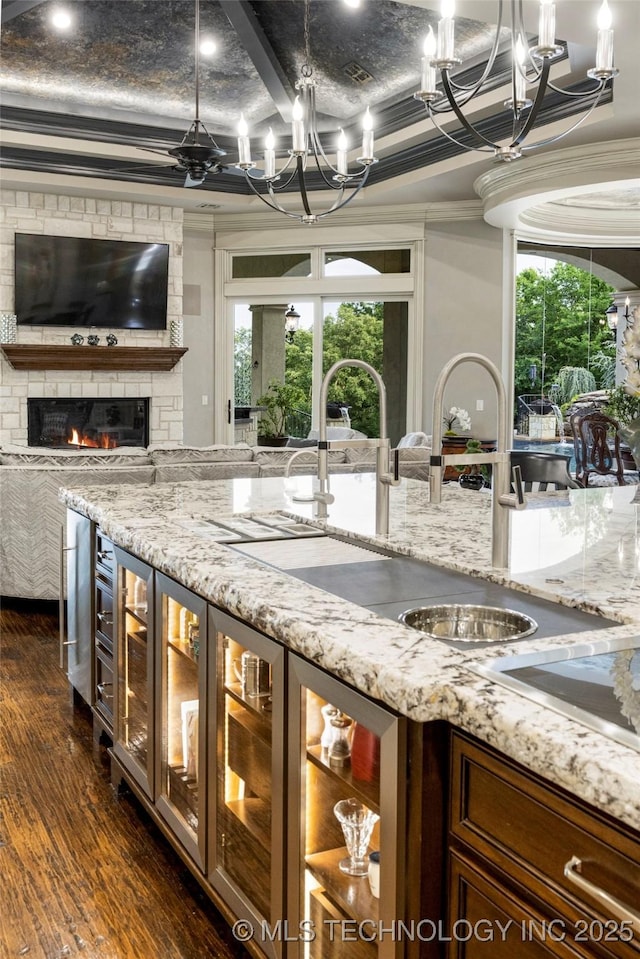 5879 N Eagle Summit Rd, Owasso, OK 74055 - kitchen with a chandelier, a sink, dark wood finished floors, open floor plan, and glass insert cabinets