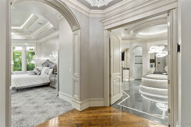 5879 N Eagle Summit Rd, Owasso, OK 74055 - hallway with a chandelier, crown molding, arched walkways, and baseboards