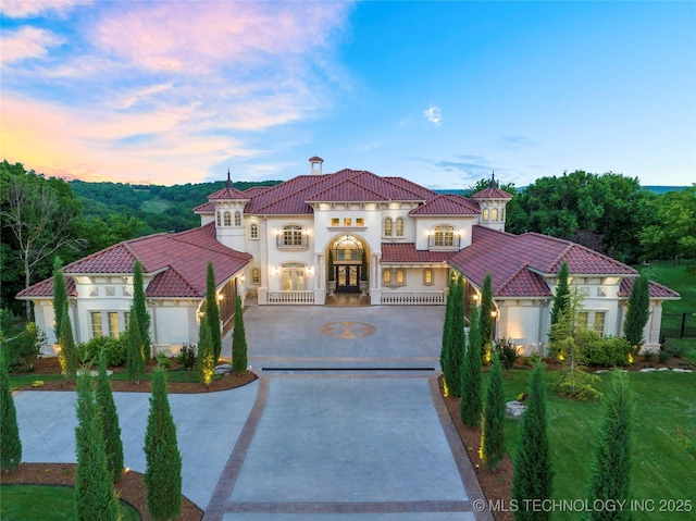 5879 N Eagle Summit Rd, Owasso, OK 74055 - mediterranean / spanish-style house featuring curved driveway, french doors, stucco siding, and a tile roof