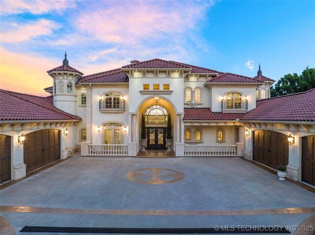 5879 N Eagle Summit Rd, Owasso, OK 74055 - mediterranean / spanish-style home featuring french doors, stucco siding, a balcony, a tile roof, and driveway