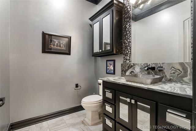 5879 N Eagle Summit Rd, Owasso, OK 74055 - bathroom featuring marble finish floors, toilet, vanity, baseboards, and crown molding
