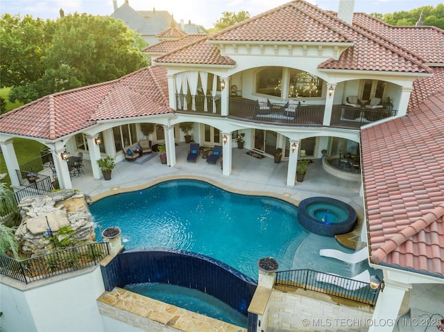 5879 N Eagle Summit Rd, Owasso, OK 74055 - back of house with a balcony, outdoor lounge area, a pool with connected hot tub, a tile roof, and a patio