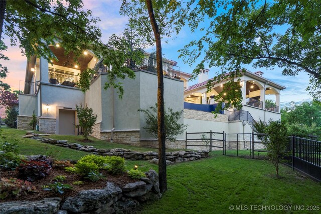 5879 N Eagle Summit Rd, Owasso, OK 74055 - view of side of home with a balcony, stone siding, and stucco siding