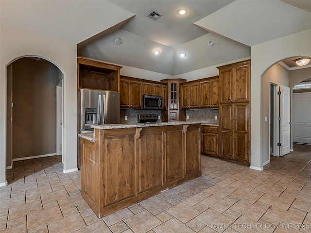 4610 E 142nd St S, Bixby, OK 74008 - kitchen with appliances with stainless steel finishes, arched walkways, a kitchen island, backsplash, and glass insert cabinets