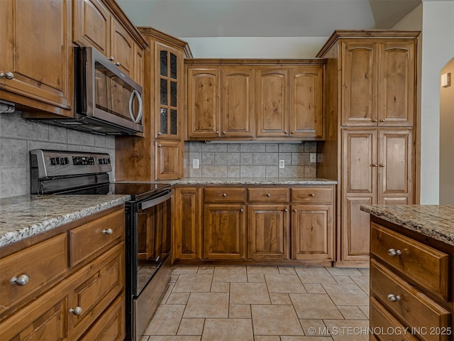 4610 E 142nd St S, Bixby, OK 74008 - kitchen featuring black range with electric stovetop, stainless steel microwave, backsplash, and light stone countertops