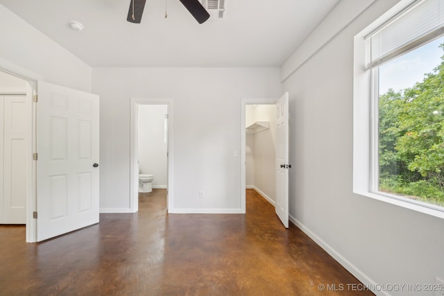 26685 Teal Cir, Henryetta, OK 74437 - unfurnished bedroom featuring concrete floors, baseboards, a spacious closet, connected bathroom, and a closet