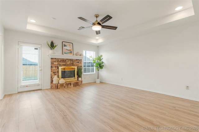 5202 Greenan Dr, Sand Springs, OK 74063 - unfurnished living room with a tray ceiling, recessed lighting, light wood-style floors, a ceiling fan, and a fireplace