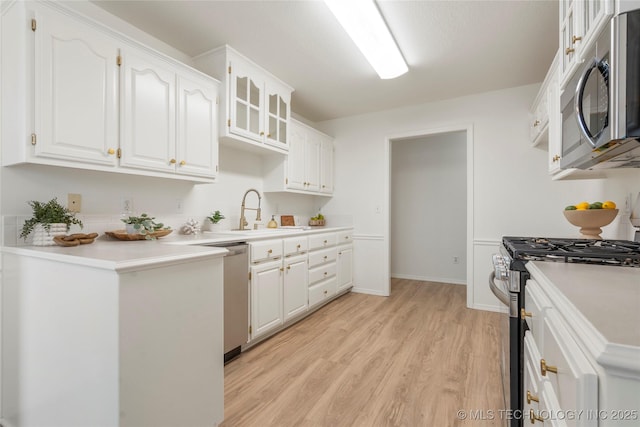5202 Greenan Dr, Sand Springs, OK 74063 - kitchen featuring appliances with stainless steel finishes, a sink, white cabinets, light wood-style floors, and light countertops
