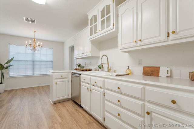 5202 Greenan Dr, Sand Springs, OK 74063 - kitchen with dishwasher, a sink, a chandelier, light wood finished floors, and white cabinetry