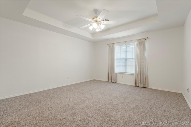 5202 Greenan Dr, Sand Springs, OK 74063 - spare room featuring a tray ceiling, light carpet, baseboards, and a ceiling fan