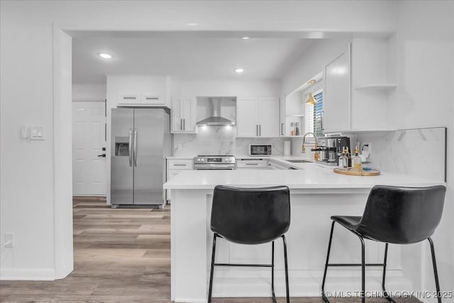 1008 E 54th St S, Tulsa, OK 74105 - kitchen with appliances with stainless steel finishes, open shelves, wall chimney range hood, a sink, and a peninsula