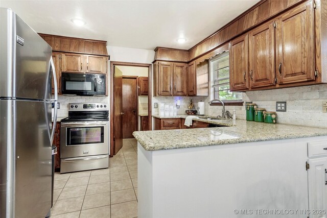 911 S Boyd Pl, Sapulpa, OK 74066 - kitchen with stainless steel appliances, a sink, a peninsula, and decorative backsplash