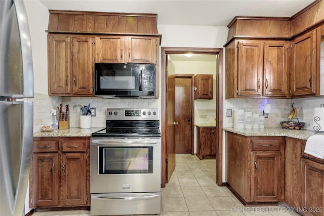 911 S Boyd Pl, Sapulpa, OK 74066 - kitchen featuring appliances with stainless steel finishes, tasteful backsplash, brown cabinetry, and light tile patterned floors