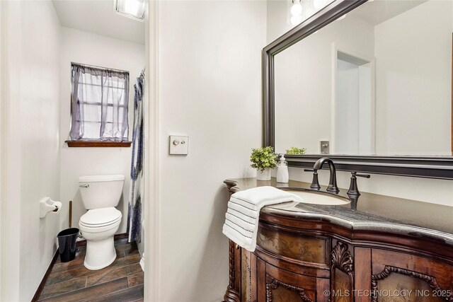 911 S Boyd Pl, Sapulpa, OK 74066 - bathroom featuring toilet, vanity, wood finished floors, and baseboards