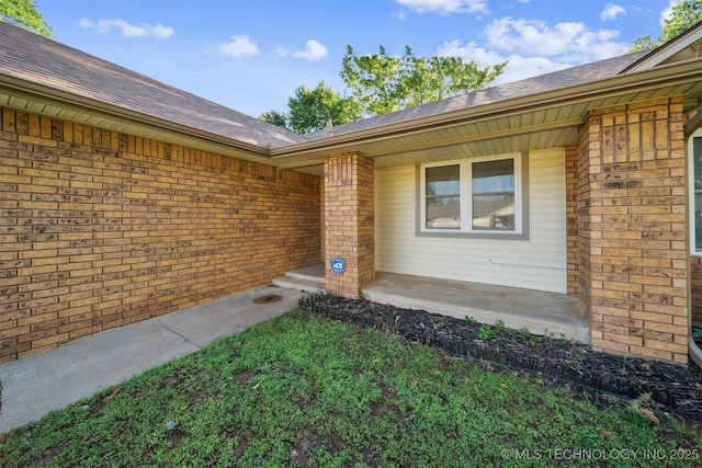 9703 N 109th E Ave, Owasso, OK 74055 - doorway to property featuring brick siding, roof with shingles, and covered porch