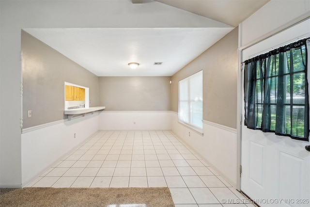 9703 N 109th E Ave, Owasso, OK 74055 - unfurnished dining area featuring light tile patterned floors, healthy amount of natural light, and lofted ceiling