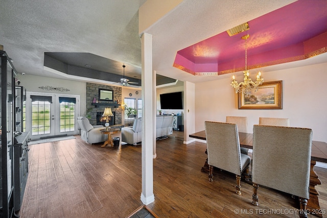 5757 W 181st St S, Mounds, OK 74047 - dining space featuring a tray ceiling, wood finished floors, a fireplace, a chandelier, and a textured ceiling