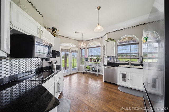5757 W 181st St S, Mounds, OK 74047 - kitchen with stainless steel appliances, a chandelier, dark countertops, decorative backsplash, and white cabinets