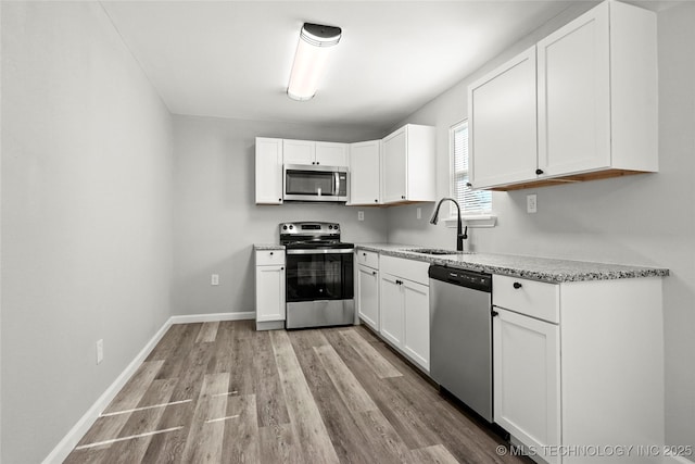 821 N 71st E Ave, Tulsa, OK 74115 - kitchen with appliances with stainless steel finishes, a sink, light wood-style floors, and white cabinetry
