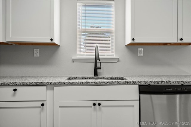 821 N 71st E Ave, Tulsa, OK 74115 - kitchen featuring dishwasher, a sink, and white cabinets