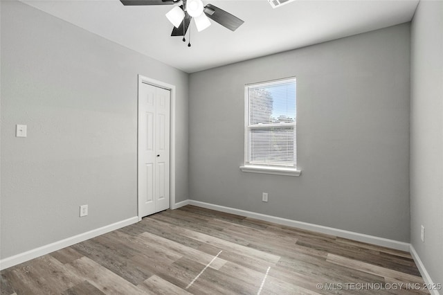 821 N 71st E Ave, Tulsa, OK 74115 - unfurnished bedroom with wood finished floors, baseboards, a closet, and a ceiling fan
