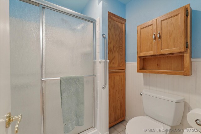 1401 E S Ave, Mcalester, OK 74501 - bathroom featuring toilet, a shower stall, wainscoting, and tile patterned floors