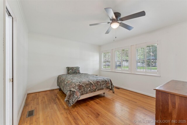 1401 E S Ave, Mcalester, OK 74501 - bedroom featuring baseboards, wood finished floors, crown molding, and a ceiling fan