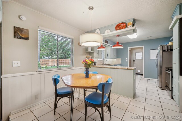 5212 S 68th E Pl, Tulsa, OK 74145 - dining space with light tile patterned floors, wainscoting, and crown molding