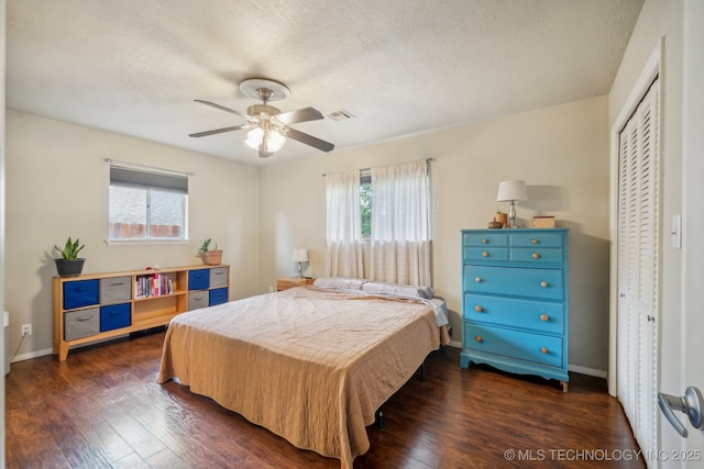 5212 S 68th E Pl, Tulsa, OK 74145 - bedroom with dark wood-style floors, a closet, a textured ceiling, a ceiling fan, and baseboards