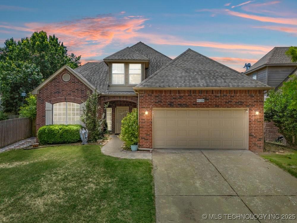 9138 E 77th St, Tulsa, OK 74133 - traditional-style home with brick siding, a garage, driveway, and a shingled roof