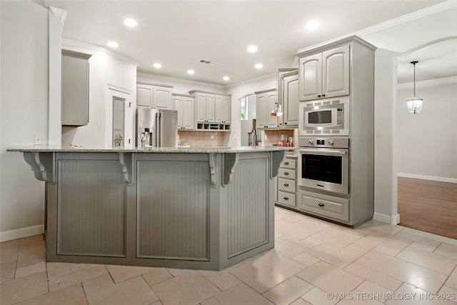 465 E 113th St S, Jenks, OK 74037 - kitchen with stainless steel appliances, a peninsula, ornamental molding, a breakfast bar area, and baseboards