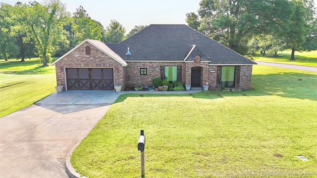 2102 N Peaceful Ln, Stigler, OK 74462 - view of front of house featuring brick siding, an attached garage, a front yard, driveway, and a shingled roof
