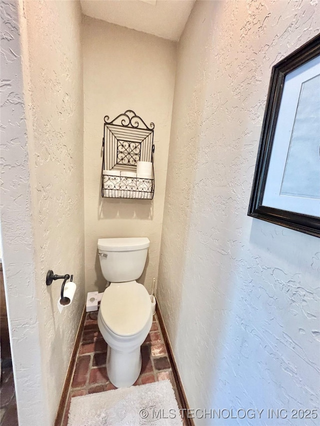 2102 N Peaceful Ln, Stigler, OK 74462 - bathroom featuring toilet, baseboards, and a textured wall