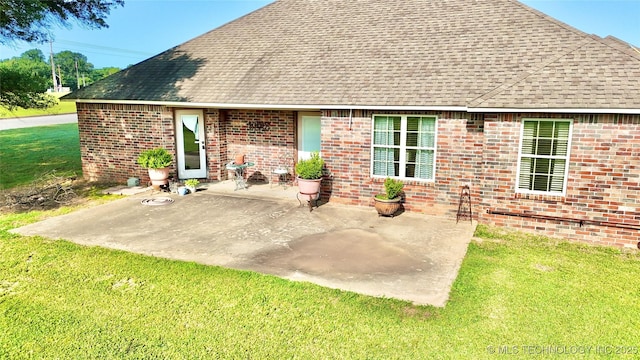 2102 N Peaceful Ln, Stigler, OK 74462 - rear view of property with a shingled roof, a patio area, a yard, and brick siding