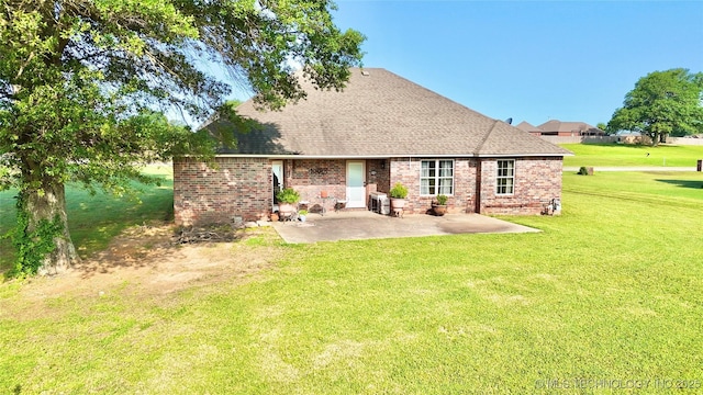 2102 N Peaceful Ln, Stigler, OK 74462 - back of property with a patio, a shingled roof, a yard, and brick siding