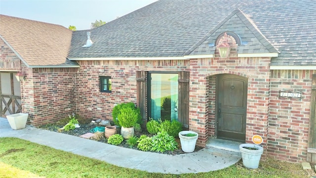 2102 N Peaceful Ln, Stigler, OK 74462 - view of exterior entry with brick siding and a shingled roof
