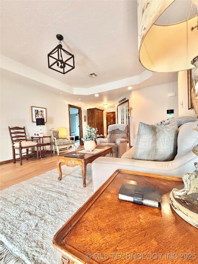 2102 N Peaceful Ln, Stigler, OK 74462 - living room featuring wood finished floors, a tray ceiling, and recessed lighting