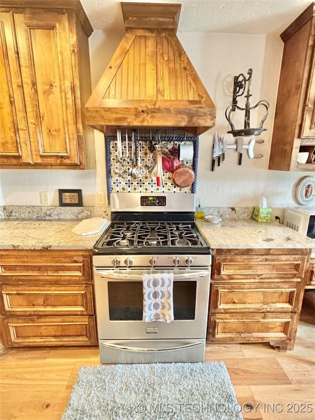 2102 N Peaceful Ln, Stigler, OK 74462 - kitchen featuring gas range, custom range hood, light wood finished floors, and light stone countertops