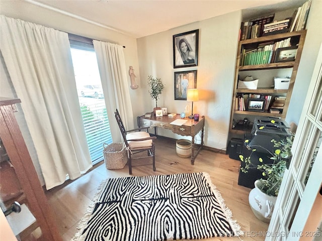 2102 N Peaceful Ln, Stigler, OK 74462 - living area with wood finished floors, a desk, and baseboards