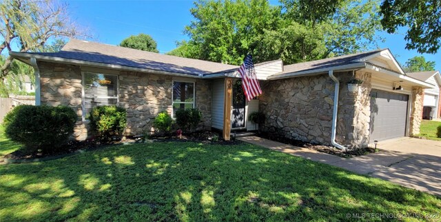 1100 Guinn Ln, Bartlesville, OK 74006 - ranch-style house with stone siding, an attached garage, a front yard, and driveway