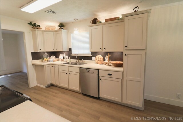 1100 Guinn Ln, Bartlesville, OK 74006 - kitchen with dishwasher, a sink, light wood-style flooring, and light countertops