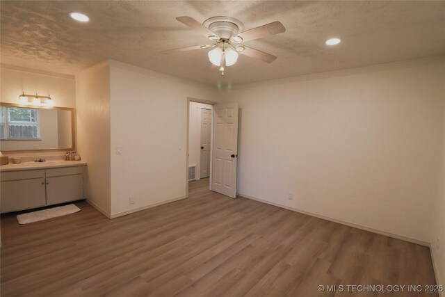 1100 Guinn Ln, Bartlesville, OK 74006 - unfurnished bedroom featuring a sink, wood finished floors, recessed lighting, baseboards, and a textured ceiling