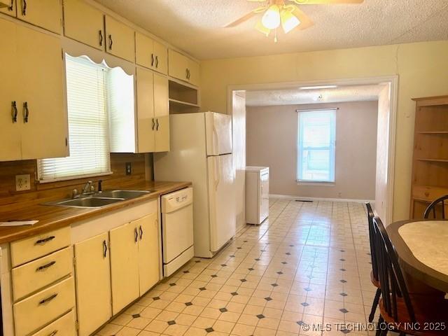 607 3rd NW, Ardmore, OK 73401 - kitchen with white appliances, a sink, a ceiling fan, a textured ceiling, and light tile patterned floors