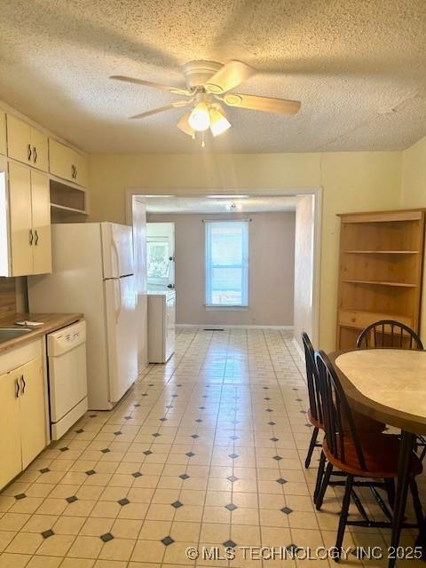 607 3rd NW, Ardmore, OK 73401 - kitchen featuring white dishwasher, a textured ceiling, a ceiling fan, white cabinets, and baseboards