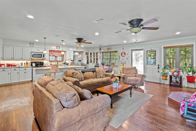1307 Chickasaw Rd, Calera, OK 74730 - living room featuring ceiling fan, healthy amount of natural light, recessed lighting, crown molding, and light wood-type flooring