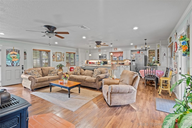 1307 Chickasaw Rd, Calera, OK 74730 - living room with recessed lighting, ornamental molding, ceiling fan, a chandelier, and light wood-style flooring